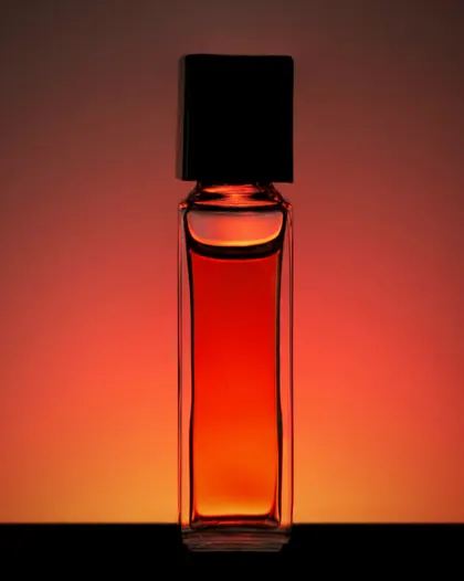 A bottle of Araar Najd glowing amber against warm light