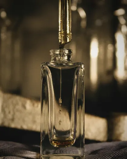 A pipette above a perfume bottle in the house atelier